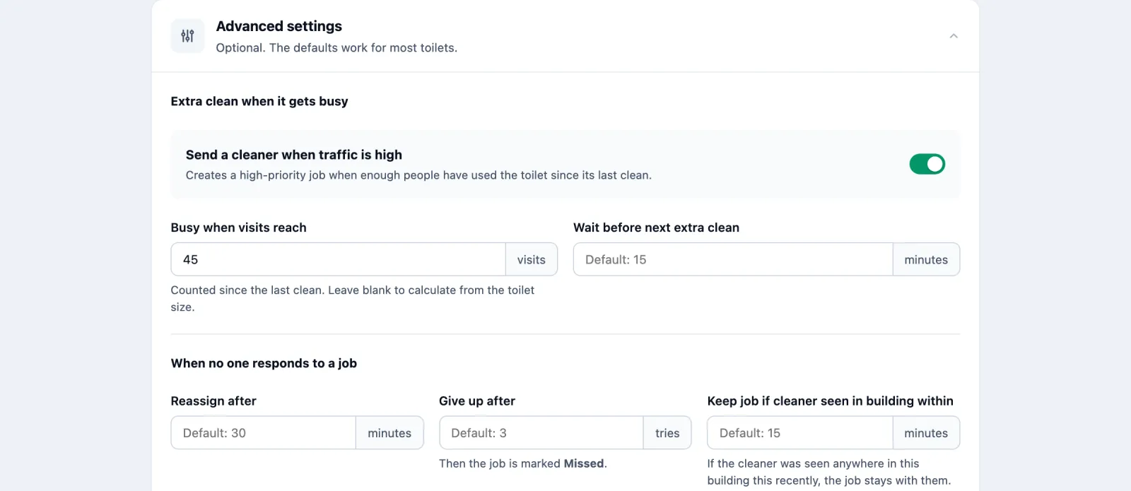 Advanced settings on the toilet's edit form, opened. Extra clean when it gets busy: Send a cleaner when traffic is high, switched on; Busy when visits reach 45 visits, counted since the last clean, leave blank to calculate from the toilet size; Wait before next extra clean, default 15 minutes. When no one responds to a job: Reassign after, default 30 minutes; Give up after, default 3 tries, then the job is marked Missed; Keep job if cleaner seen in building within, default 15 minutes.